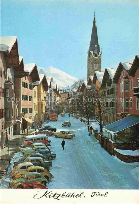 Kitzbuehel Tirol AT Hauptstrasse Kirchturm Winterszene Autos Fussgaenger Schnee