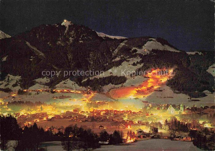 Kitzbuehel Tirol AT Nachtaufnahme Hahnenkamm Nachtpiste Stadtlichter Winter Schn