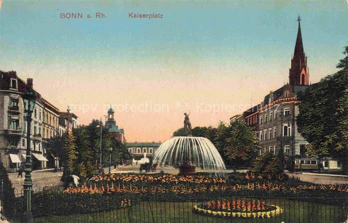 BONN Rhein Kaiserplatz Brunnen Kirchturm Strassenbahn Blumenbeete Gebaeude Baeum