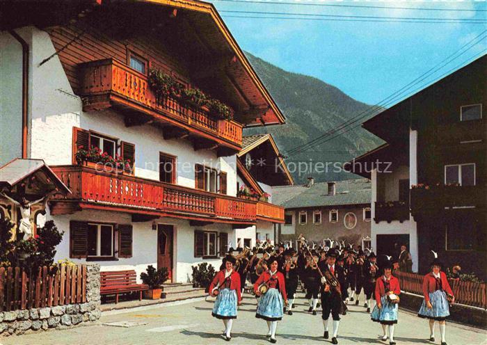 Stans Tirol AT Musikkapelle Tracht Blasmusik Dorfstrasse Haeuser Berge Unterinnt