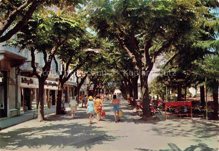 GRADO Gorizia IT Viale-Europa Allee Promenade Geschaefte Passanten Baeume Strass