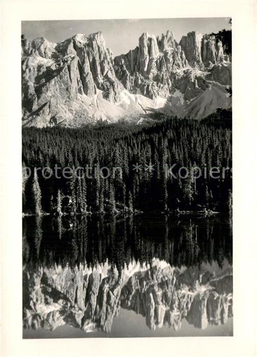 Karersee Suedtirol gegen Latemar Dolomiten Bergsee Wasserspiegelung