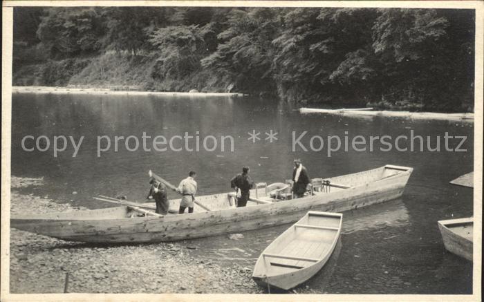 Amerika Alaska Maenner mit Booten am Fluss