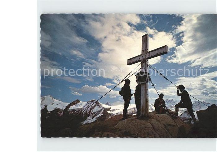 Kitzsteinhorn Bergsteiger am Gipfelkreuz mit Grossglocknergruppe