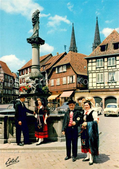 Cigogne Jeunes gens en costumes regionaux sur la place a Obernai